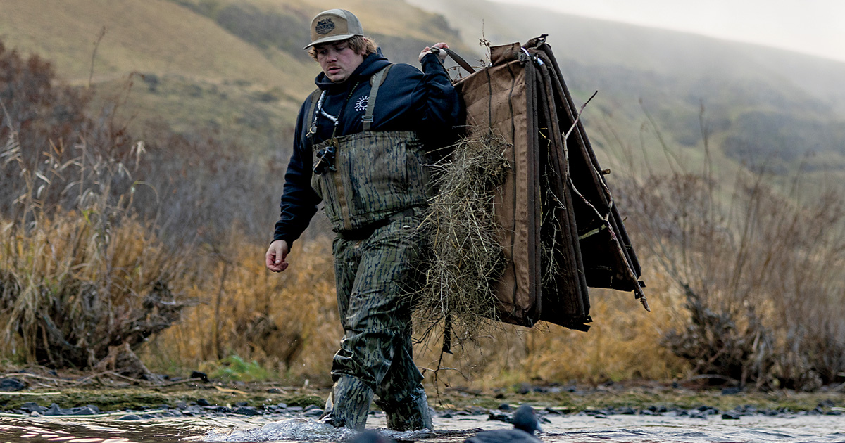 Duck hunter carrying a Higdon Outdoors H-Frame Panel Blind through a wetland. Photo by HigdonOutdoors.com.jpg