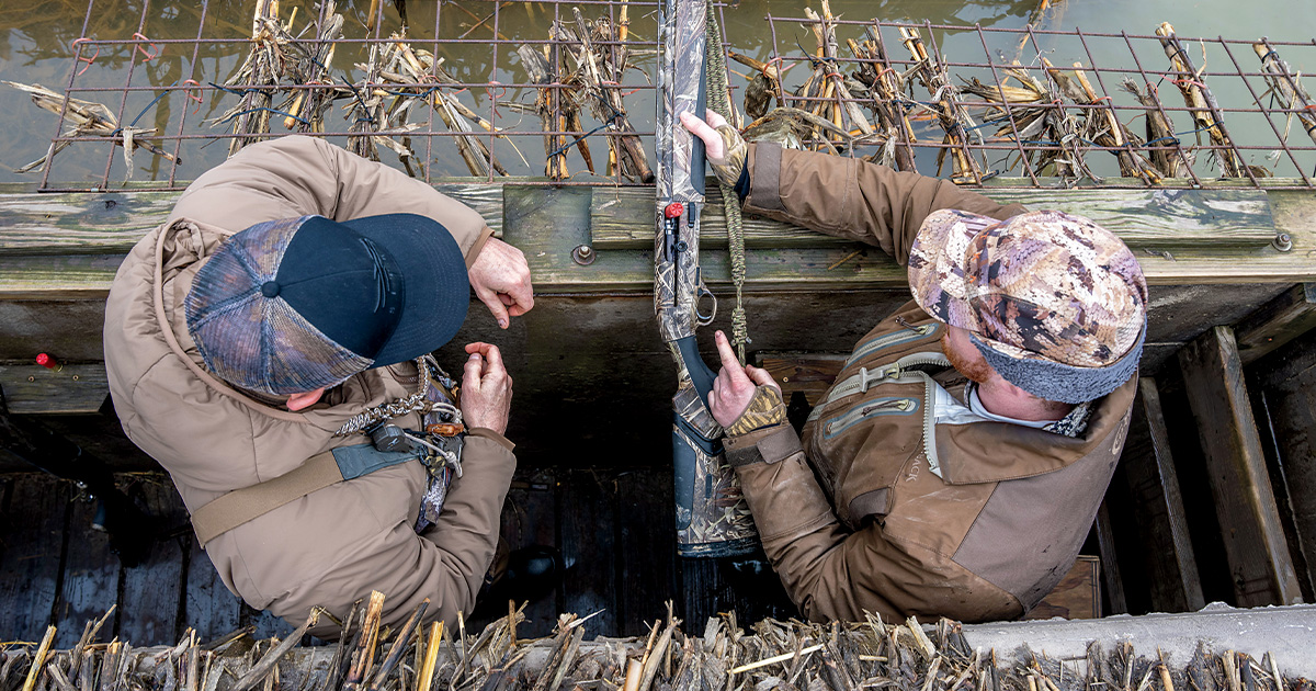 Waterfowl hunters inspecting shotgun. Photo by LeahyPhoto.com